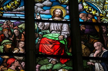 Stained glass window depicting the Sermon on the Mount by Christ. clipart