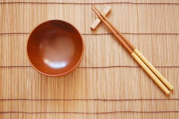 Ätpinnar med trä skål på bambu mattor bakgrund — Stockfoto