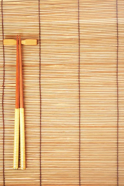 Палочки для еды на коричневом бамбуковом фоне — стоковое фото