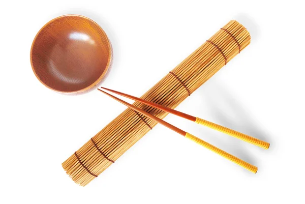 Válcované bambusová rohož s dvojicí hůlky a dřevěná mísa — Stock fotografie