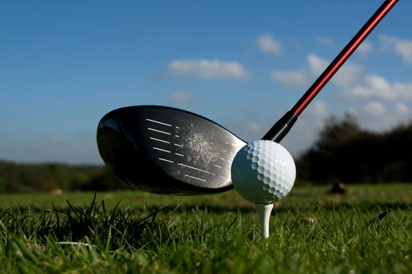 Golf förare och bollen på tee blå himmel — Stockfoto