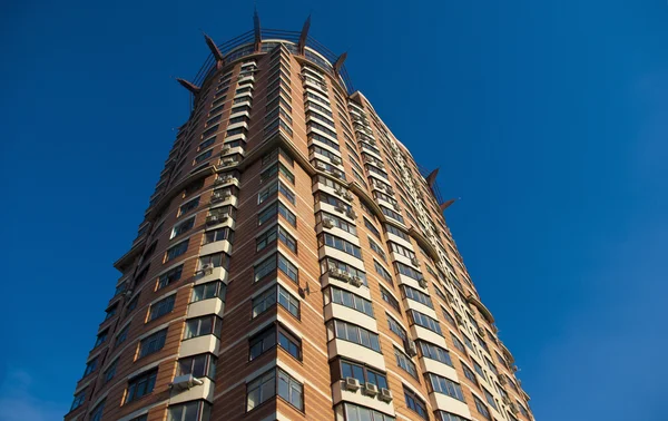 Construção de um edifício moderno contra um fundo de céu azul — Fotografia de Stock