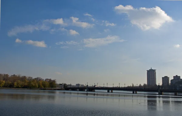 Most przez rzekę w mieście na tle niebieski s — Zdjęcie stockowe