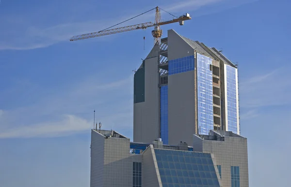 การก่อสร้างอาคารสมัยใหม่กับพื้นหลังของท้องฟ้าสีฟ้า — ภาพถ่ายสต็อก