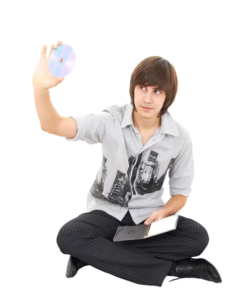 Photo of young stylish man sitting and holding a cd dvd isolated — Stock Photo, Image