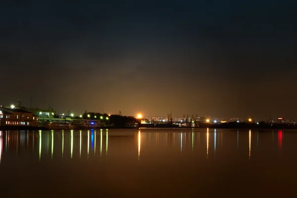 Stock image City at night. Port cranes and river