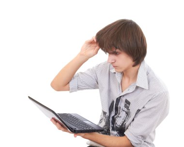 Teen looks to notebook and raises his glasses in surprize clipart