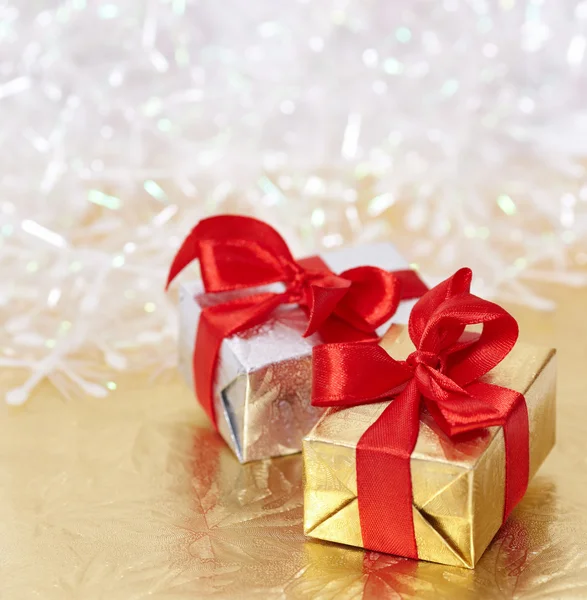 Cajas de regalo sobre fondo reflectante dorado y blanco brillante — Foto de Stock