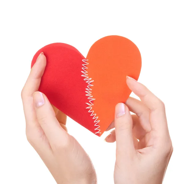 Corazón de San Valentín cosido de dos mitades en las manos de la mujer — Foto de Stock