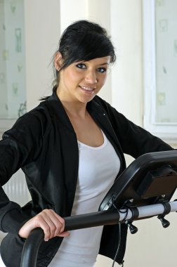 Photo of young woman in gym. clipart