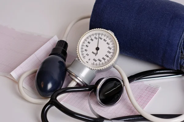 stock image Photo of pressure gauge over a electrocardiogram close up.