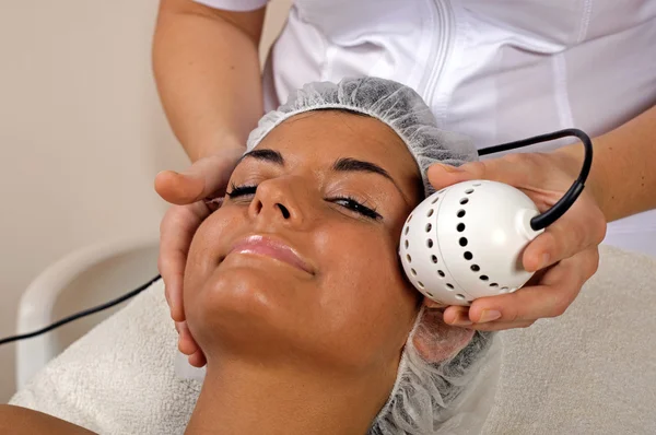 Bella giovane donna ottenere massaggio facciale . — Foto Stock