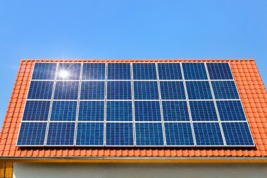 Solar panel on a roof under the cloudless sky clipart