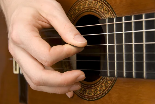 Guitar player's högra hand plocka strängarna — Stockfoto