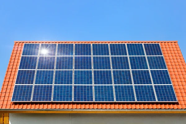 Solární panel na střeše pod bezmračnou oblohou — Stock fotografie