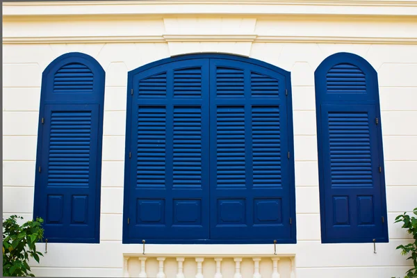 Niebieski okiennice na ścianie krem Zdjęcie Stockowe
