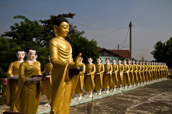 Estatua de Buda y discípulos son limosnas alrededor en el templo myanmar —  Fotos de Stock