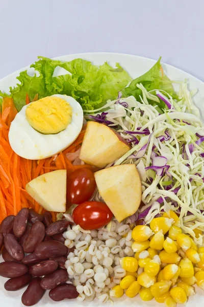 Фруктовый салат с вареным яйцом на белой тарелке — стоковое фото