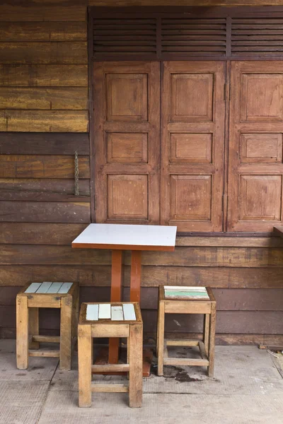 stock image Wooden tables and chairs near the old window