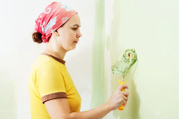 Mujer Joven Pintando Pared Blanca Con Pintura Verde Imágenes de stock libres de derechos