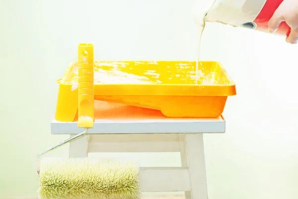 stock image Pouring green paint from the bucket to the tray
