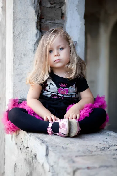 Υπέροχο μικρό παιδί ξανθό κορίτσι που κάθεται πάνω σε ερείπια — Φωτογραφία Αρχείου