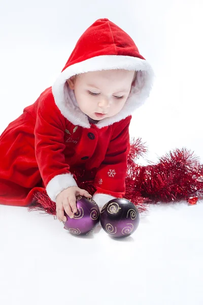 Malá vánoční dítě hraje s novoroční míčky — Stock fotografie