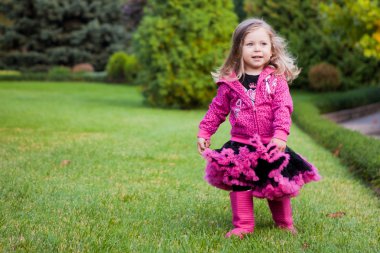 Beautiful girl running on a grass in a garden clipart