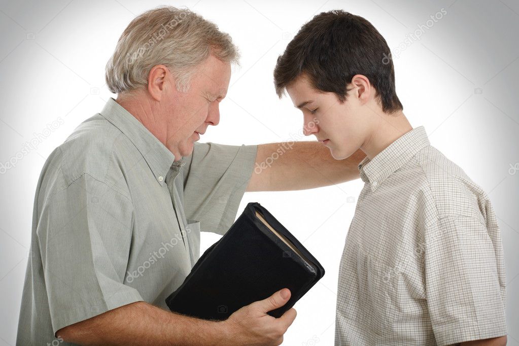 Father leading his son in prayer to receive Jesus