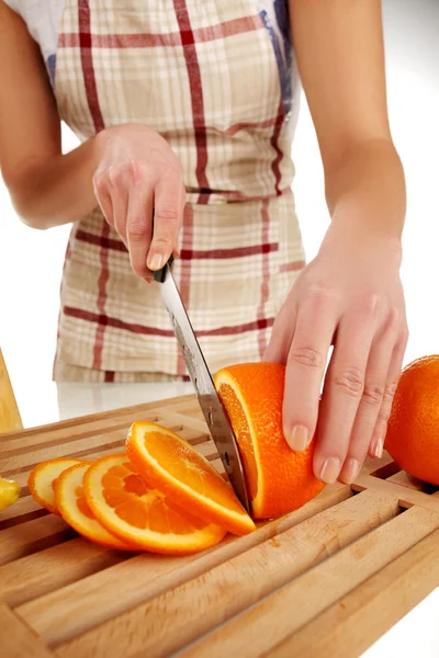 Meisje Snijden Oranje Met Het Mes Een Houten Bord — Stockfoto