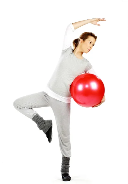 Девушка упражняется с красным мячом — стоковое фото