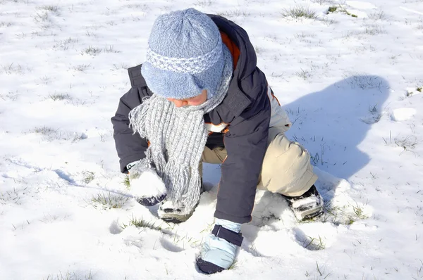 Chico jugando en la nieve — Foto de Stock