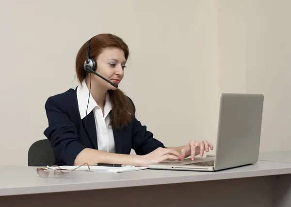 Business woman work on laptop in headset