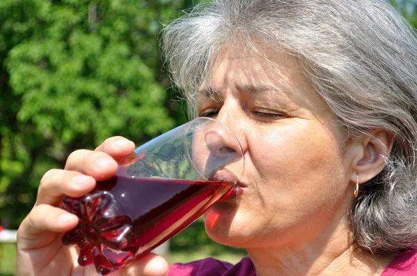 Женщина пьет охлажденный вишневый сок — стоковое фото