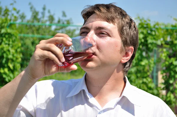 El hombre bebe jugo de cereza refrigerado — Foto de Stock