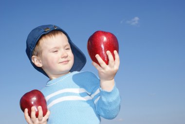 The boy is holding a large red apples clipart