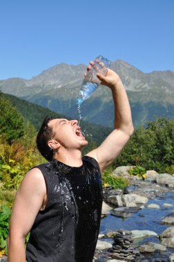 genç bir adamın kafasına plastik bir şişe su dökülen,