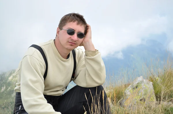 stock image A young man sits on a hilltop