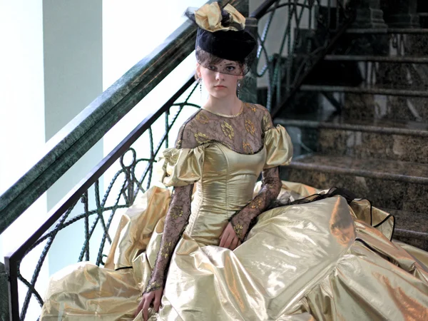 Молодая женщина в платье золотого цвета Telifsiz Stok Fotoğraflar