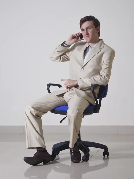 Молодой человек в офисе разговаривает по телефону Стоковое Изображение