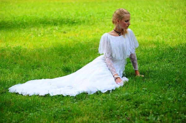 Bir çim üzerinde eski bir beyaz elbiseli genç kız — Stok fotoğraf