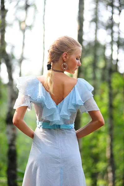 Jong meisje in een blauwe jurk in het park — Stockfoto