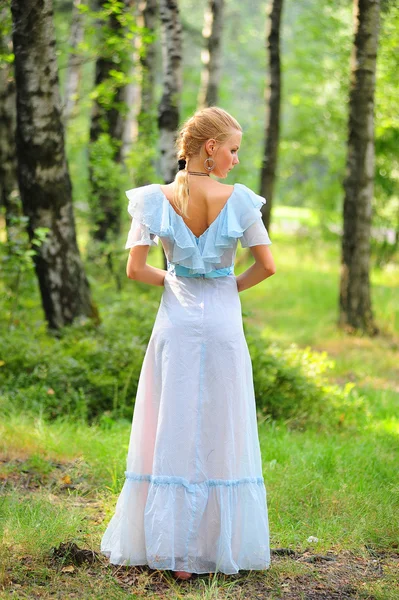 Junges Mädchen im blauen Kleid im Park — Stockfoto