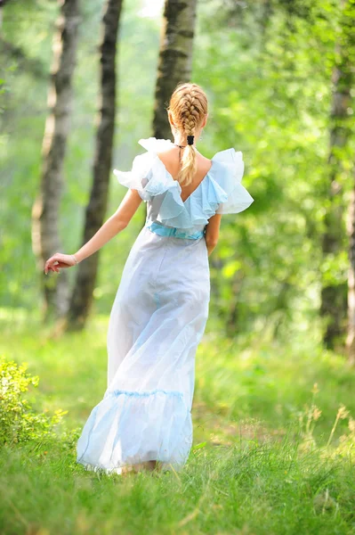 Ung flicka i en blå klänning i parken — Stockfoto