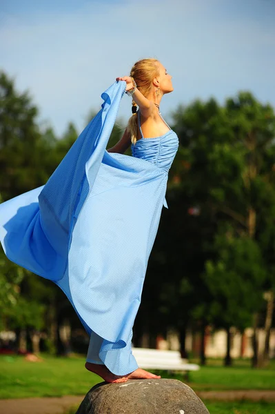Mladá dívka v modrých šatech v parku — Stock fotografie