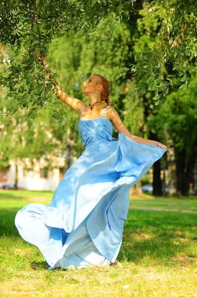 Jovem em um vestido azul no parque — Fotografia de Stock