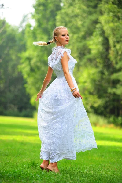 하얀 드레스를 입고 포즈를 취하는 공원에서 소녀 — 스톡 사진