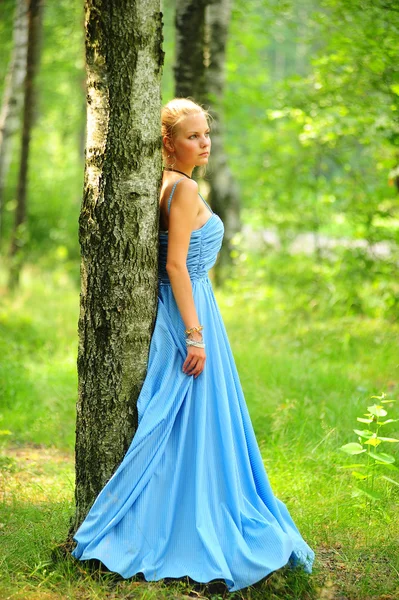 Young girl in a blue dress in the park — Stock Photo, Image
