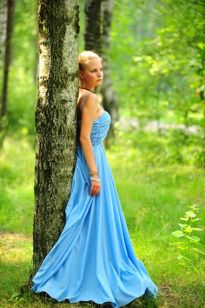 Young girl in a blue dress in the park — Stock Photo, Image