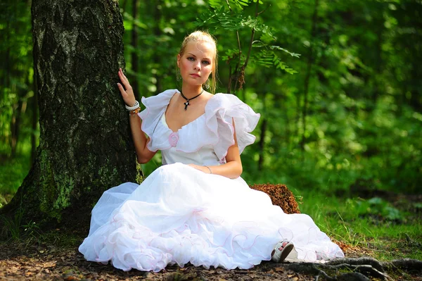 Den unga flickan i en gammal vit klänning på en gräs — Stockfoto